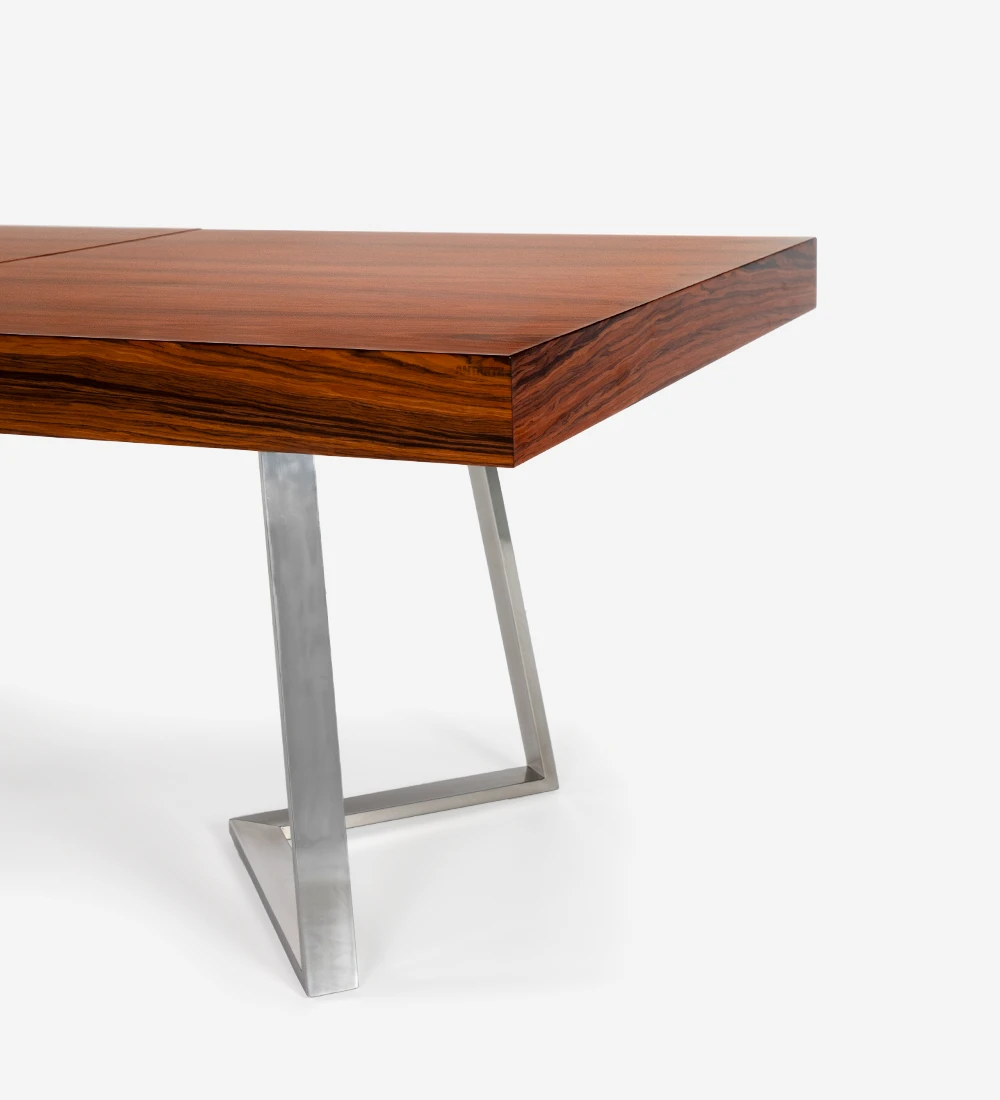 Mesa de comedor rectangular extensible con tablero de palisandro alto brillo y pie de acero inoxidable.
