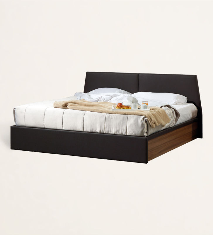 Cama de casal com cabeceira e peseira estofada a ecopele, laterais em nogueira, com arrumação através de estrado elevatório.