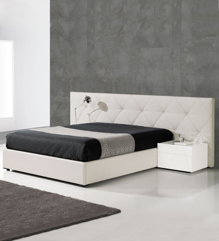 Cama de casal com cabeceira longa, estofada a ecopele branca, com arrumação através de estrado elevatório.