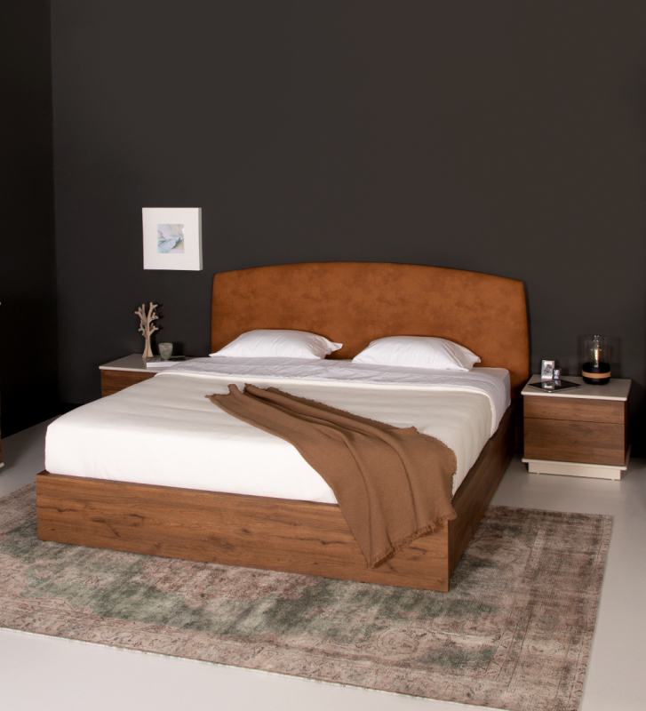 Cama de casal com cabeceira estofada a tecido e base em carvalho envelhecido, com arrumação através de estrado elevatório.