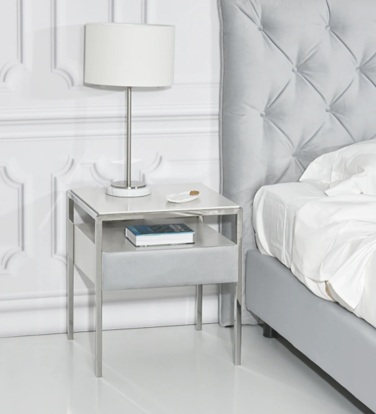 Bedside table with 1 drawer with fabric upholstered front, pearl lacquered top and drawer module, stainless steel foot.